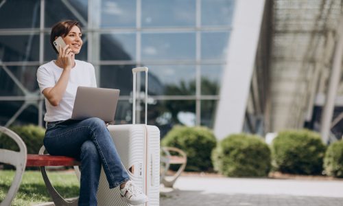 Woman travelling and working on computer at airport